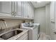 Laundry room with white cabinets and granite countertop at 2195 Harbourside Dr # 404, Longboat Key, FL 34228