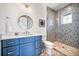 Modern bathroom with blue vanity and patterned tile shower at 2213 Avenue B, Bradenton Beach, FL 34217