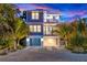 Two-story house with a gray exterior, two-car garage, and palm trees at 2213 Avenue B, Bradenton Beach, FL 34217