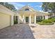 House exterior with columns, green roof, and stone driveway at 227 Saint James Park, Osprey, FL 34229