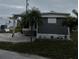 Mobile home exterior features a gray facade, covered patio, and landscaping at 2601 Gulf N Dr # S2, Bradenton Beach, FL 34217