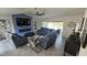 Living room with lake view, leather sofas, fireplace, and large TV at 3001 Seasons Blvd, Sarasota, FL 34240