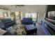 Spacious living room with leather sofas, a large TV, and access to a screened patio at 3001 Seasons Blvd, Sarasota, FL 34240