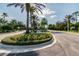 Landscaped entrance to community with palm trees and flowering plants at 314 Mystic Falls Dr, Apollo Beach, FL 33572