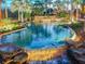 Evening view of resort-style pool with waterfall and lush landscaping at 314 Mystic Falls Dr, Apollo Beach, FL 33572