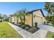 Side view of a yellow house with a single-car garage and lush landscaping at 314 Mystic Falls Dr, Apollo Beach, FL 33572