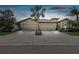 Front view of a two-story house with a three-car garage and palm trees at 314 Mystic Falls Dr, Apollo Beach, FL 33572