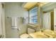 Small bathroom with a toilet, sink, shower, and window at 3465 Winding Oaks Dr # 33, Longboat Key, FL 34228