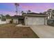 Single-story home with a two-car garage and landscaped front yard at 3623 Giblin Dr, North Port, FL 34286