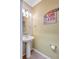 Small half bathroom with pedestal sink and beach-themed decor at 3766 82Nd Avenue E Cir # 106, Sarasota, FL 34243