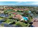 Aerial view of community pool, tennis courts, and lush landscaping at 3803 Wilshire W Cir # 37, Sarasota, FL 34238