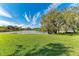 Grass lawn and lake view in sunny backyard at 3803 Wilshire W Cir # 37, Sarasota, FL 34238