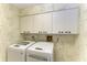 Laundry room with washer, dryer and overhead cabinets at 3803 Wilshire W Cir # 37, Sarasota, FL 34238