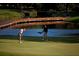 Golfers enjoying a putting green beside a pond and wooden bridge at 385 N Point Rd # 402, Osprey, FL 34229