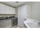 Laundry room with washer, dryer, cabinets, and a utility sink at 385 N Point Rd # 402, Osprey, FL 34229