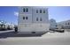 Rear view of a light blue townhome with a double garage and paved parking area at 407 Gowdy Rd, Sarasota, FL 34237