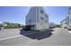 Rear view of a light blue home with a double garage and paved parking area at 407 Gowdy Rd, Sarasota, FL 34237