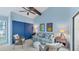 Relaxing bedroom with a blue accent wall and comfortable seating area at 4372 Woodmans Chart # 143, Sarasota, FL 34235