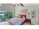 Bright bedroom with red bed frame and garden view at 4372 Woodmans Chart # 143, Sarasota, FL 34235