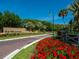 The Meadows community entrance with red flowers and brick road at 4372 Woodmans Chart # 143, Sarasota, FL 34235