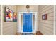 Inviting entryway with a vibrant blue door and unique wall art at 4372 Woodmans Chart # 143, Sarasota, FL 34235