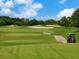 Golf course with a golf cart on a sunny day at 4372 Woodmans Chart # 143, Sarasota, FL 34235