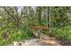 Wooden footbridge crossing a lush, natural creek area with abundant foliage at 4372 Woodmans Chart # 143, Sarasota, FL 34235