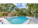 Community pool with lounge chairs and shaded area at 4372 Woodmans Chart # 143, Sarasota, FL 34235