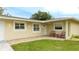 Front entry of the home with two red chairs and landscaped yard at 5425 Skyline Pl, Sarasota, FL 34232