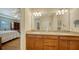 Double vanity bathroom with granite countertops and large mirror, view of bedroom at 5552 Eagle Creek Rd, Sarasota, FL 34238