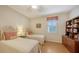 Charming bedroom featuring twin beds, wood floors, and a window with plantation shutters at 5552 Eagle Creek Rd, Sarasota, FL 34238