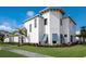 Luxury home with white stucco exterior, blue shutters, and manicured landscaping at 5902 Red Mangrove Ln, Bradenton, FL 34210