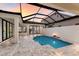 Private pool and patio area with a glass enclosure and fire pit at 5902 Red Mangrove Ln, Bradenton, FL 34210