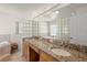 Bathroom with granite double vanity and a soaking tub at 605 Jungle Queen Way, Longboat Key, FL 34228