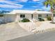 Exterior view of a single story home with a white metal roof and attached garage at 605 Jungle Queen Way, Longboat Key, FL 34228