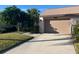 Attached garage with a large driveway and mature landscaping at 6085 Clubside Dr # 7682, Sarasota, FL 34243