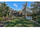 Landscaped backyard with a bench and mature trees at 662 Fernwalk Ln, Osprey, FL 34229