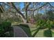 Brick pathway meanders through a beautifully landscaped garden at 662 Fernwalk Ln, Osprey, FL 34229