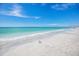 Relaxing beach with white sand and clear water under a sunny sky at 713 Saint Judes S Dr # 2, Longboat Key, FL 34228