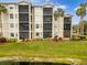 Building exterior, featuring balconies and lush landscaping at 7803 Grand Estuary Trl # 102, Bradenton, FL 34212