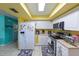 White kitchen cabinets, stainless steel appliances, and yellow ceiling at 817 Linnaen Nw Ter, Port Charlotte, FL 33948