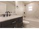 Modern bathroom with marble tile, dark vanity, and bathtub at 1109 Harbor Blvd, Port Charlotte, FL 33952