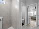 Modern bathroom with shower, toilet, and view into bedroom at 11771 Richmond Trl, Parrish, FL 34219