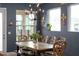 Light-filled dining area with a rustic farmhouse table and chairs, and an elegant chandelier at 11771 Richmond Trl, Parrish, FL 34219