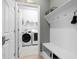 Laundry room with washer, dryer, and built-in bench at 11771 Richmond Trl, Parrish, FL 34219