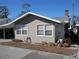 Gray siding home with a manicured lawn and mature trees at 12 Desoto E St, Bradenton, FL 34208