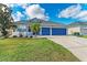 Two-story house with blue garage doors and well-manicured lawn at 12219 23Rd E St, Parrish, FL 34219