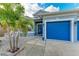 Front entry and blue garage doors of a house with palm trees at 12219 23Rd E St, Parrish, FL 34219