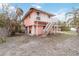 View of the back of a pink two story house with a wooden staircase at 128 51St St # A, Holmes Beach, FL 34217