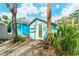 Inviting light blue guest house with a yellow door, surrounded by lush landscaping at 1330 Cocoanut Ave, Sarasota, FL 34236